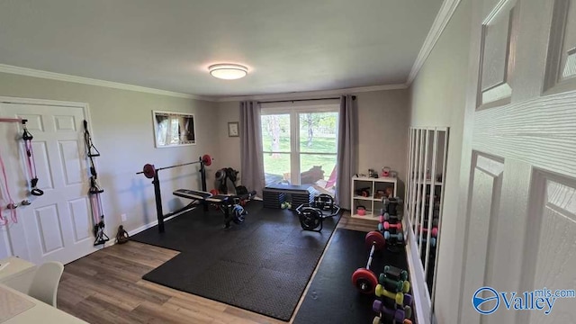 exercise area featuring baseboards, ornamental molding, and wood finished floors