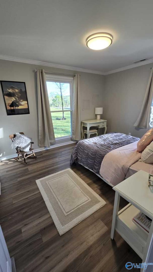 bedroom featuring crown molding, wood finished floors, baseboards, and visible vents