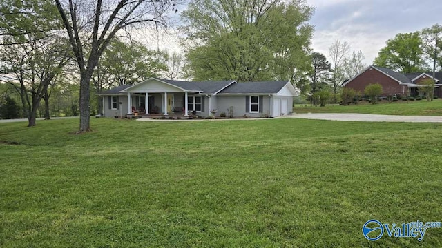 single story home with an attached garage, a front lawn, driveway, and covered porch