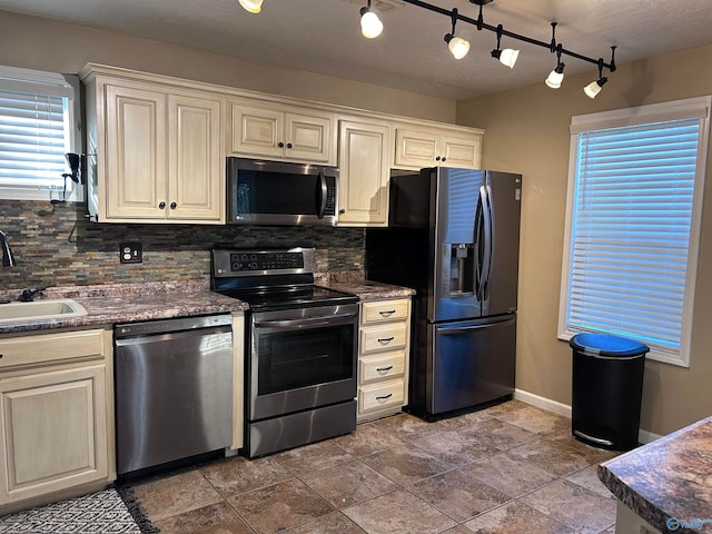 kitchen with a healthy amount of sunlight, appliances with stainless steel finishes, and tasteful backsplash