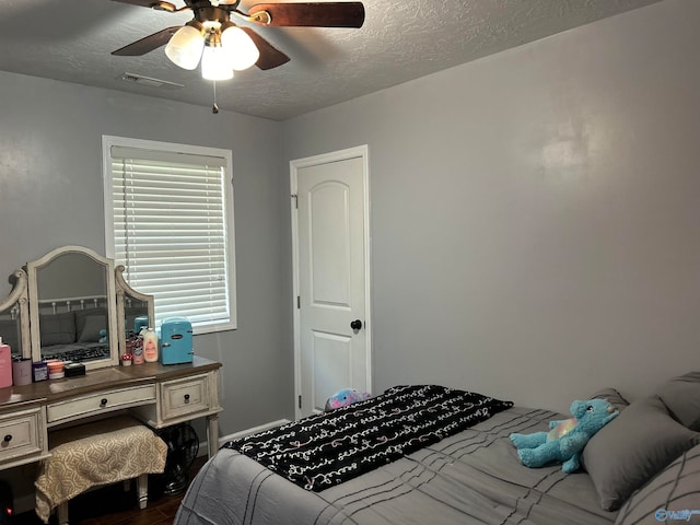 bedroom featuring ceiling fan and a textured ceiling