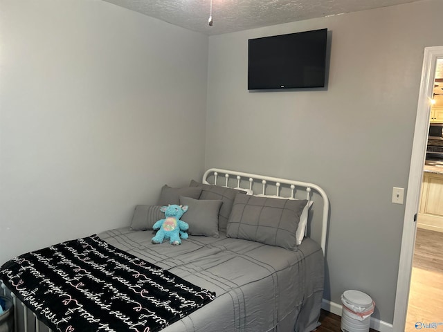 bedroom featuring hardwood / wood-style floors and a textured ceiling