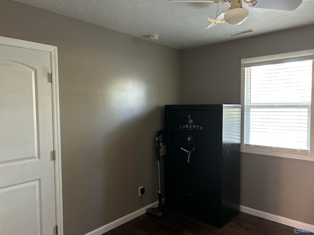 miscellaneous room with a textured ceiling, ceiling fan, and dark wood-type flooring