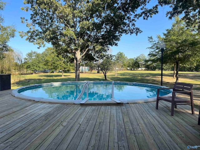 view of swimming pool with a yard and a deck