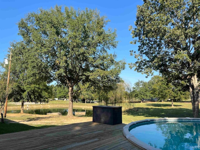 view of pool featuring a lawn and a wooden deck