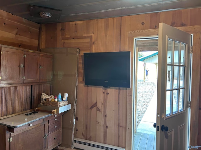 interior space featuring wood walls and baseboard heating