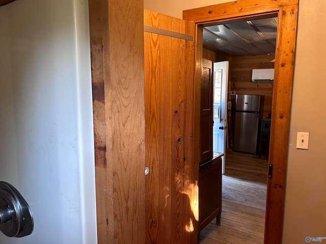 corridor with wooden walls and hardwood / wood-style flooring