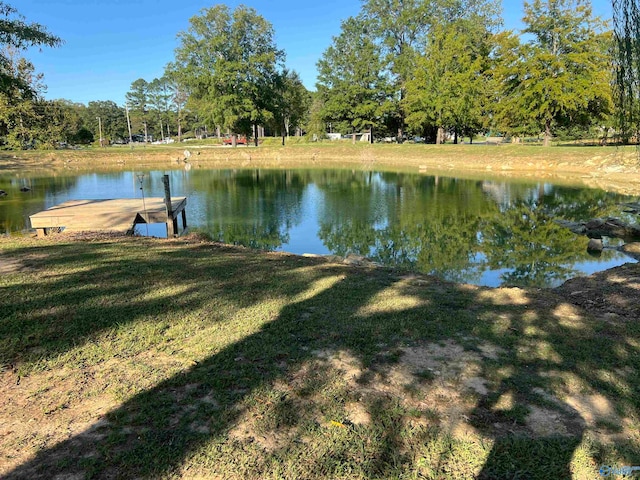 view of dock with a water view and a yard