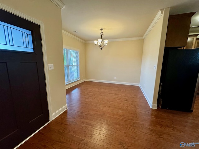 entryway featuring dark wood finished floors, crown molding, baseboards, and an inviting chandelier