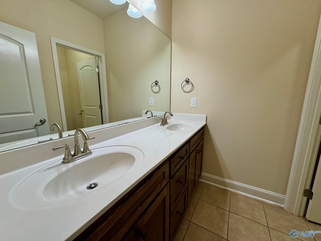 full bathroom featuring double vanity, tile patterned flooring, a sink, and baseboards