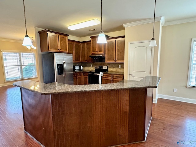 kitchen with decorative backsplash, dark stone counters, dark wood-style floors, stainless steel appliances, and crown molding