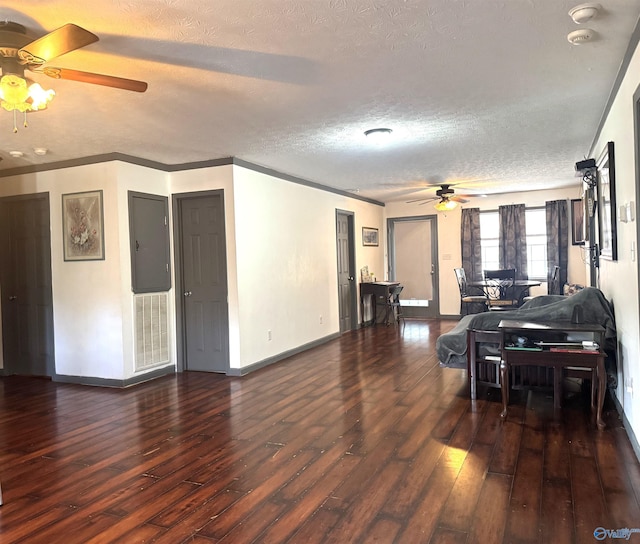 living room featuring ceiling fan, dark wood-type flooring, a textured ceiling, and crown molding