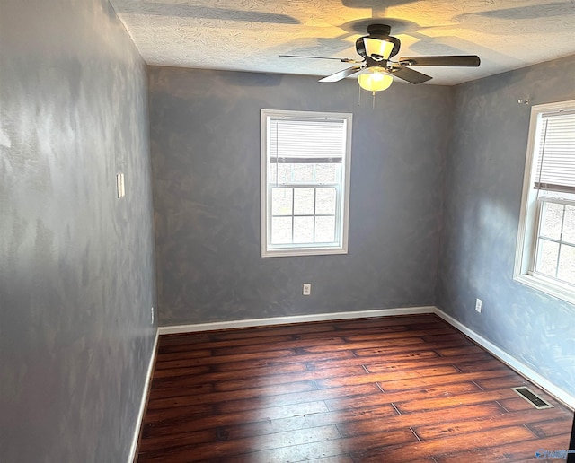 unfurnished room with ceiling fan, dark wood-type flooring, and a textured ceiling