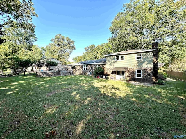 rear view of property with a lawn