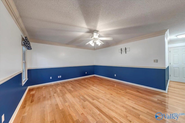 unfurnished room with ornamental molding, a ceiling fan, a textured ceiling, wood finished floors, and baseboards