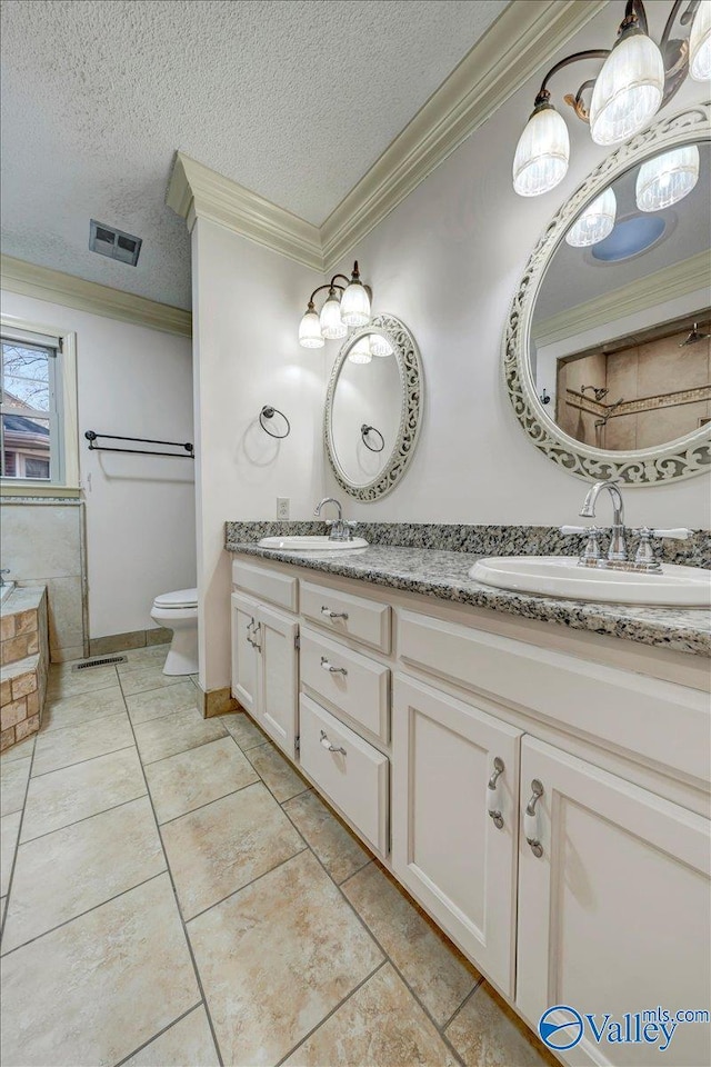 full bath with a sink, visible vents, and crown molding