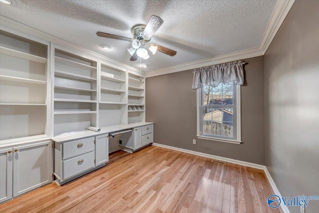 unfurnished office with light wood-type flooring, crown molding, a textured ceiling, and baseboards