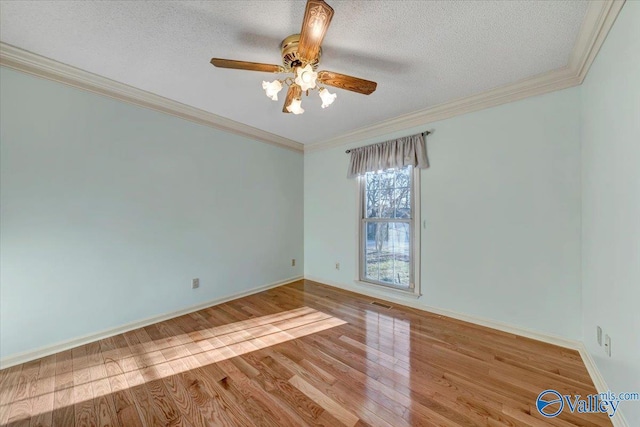 spare room with a textured ceiling, ceiling fan, wood finished floors, and crown molding