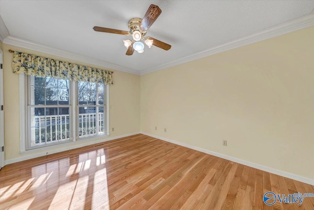 empty room with crown molding, light wood-style flooring, baseboards, and ceiling fan