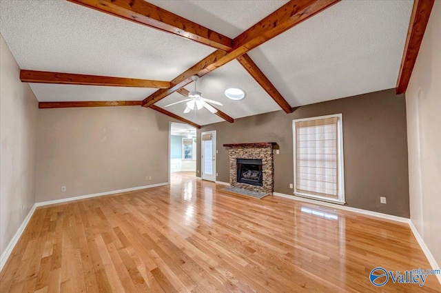 unfurnished living room featuring light wood-type flooring, plenty of natural light, a fireplace, and a ceiling fan