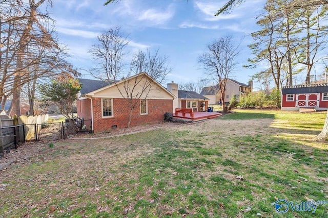 view of yard with an outbuilding, a fenced backyard, and a wooden deck