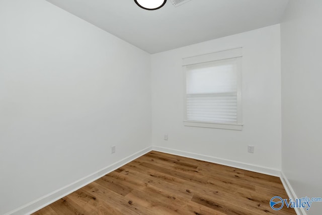 unfurnished room with baseboards and wood finished floors