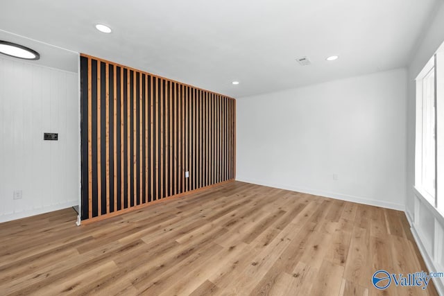 empty room with light wood-type flooring, recessed lighting, and baseboards