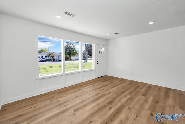 empty room featuring recessed lighting, baseboards, visible vents, and wood finished floors