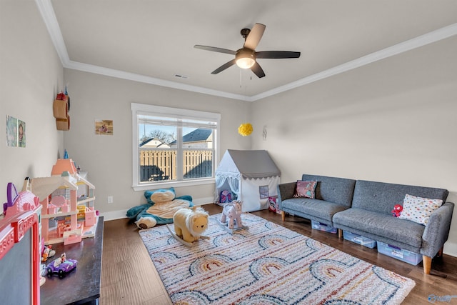 playroom featuring crown molding, ceiling fan, and dark hardwood / wood-style floors