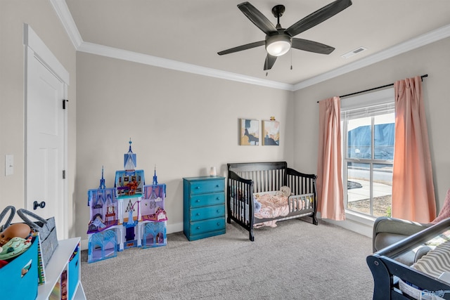 bedroom featuring a crib, ornamental molding, light carpet, and ceiling fan