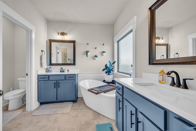 bathroom with vanity, toilet, and a washtub