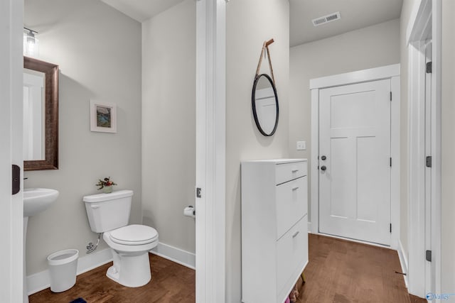 bathroom featuring wood-type flooring and toilet