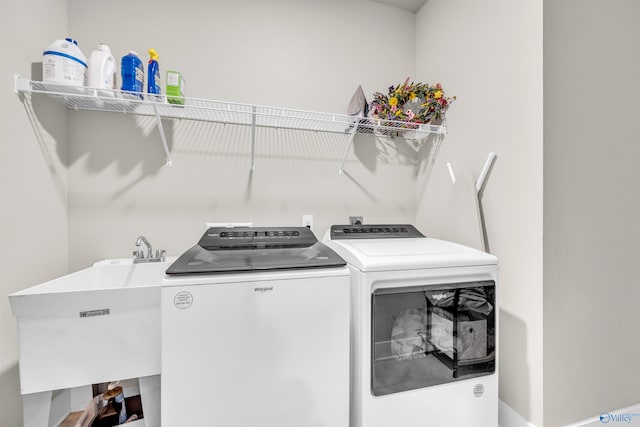 clothes washing area featuring sink and washing machine and clothes dryer