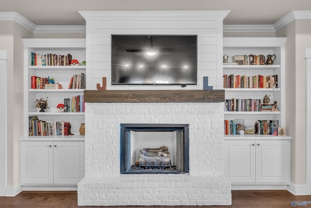 living room featuring ornamental molding, dark hardwood / wood-style floors, a fireplace, and built in shelves