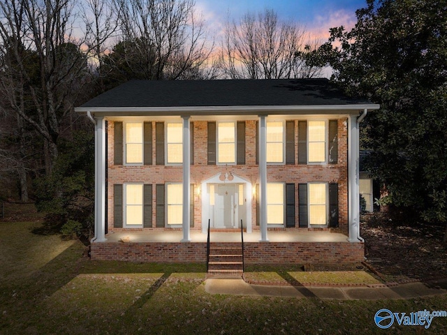 view of front of home featuring a patio area and brick siding