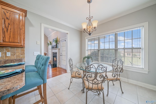 26409 Pepper Rd, Athens, AL 35613 - dining room featuring a warm lit fireplace, light tile patterned floors, crown molding, and a wealth of natural light