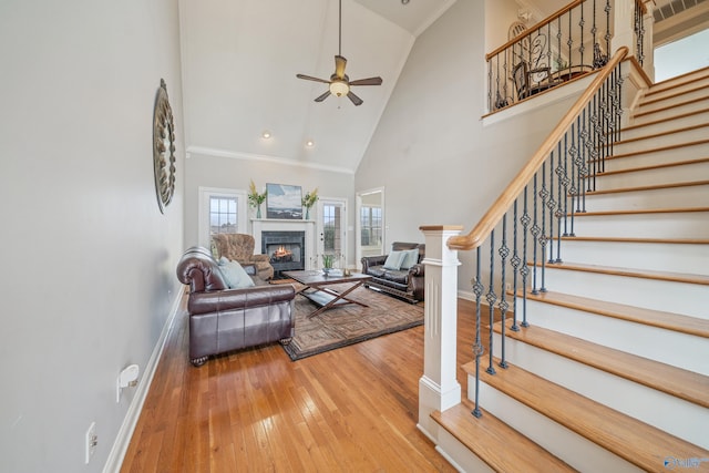 26409 Pepper Rd, Athens, AL 35613 - living area with high vaulted ceiling, hardwood / wood-style flooring, stairway, a ceiling fan, and a lit fireplace