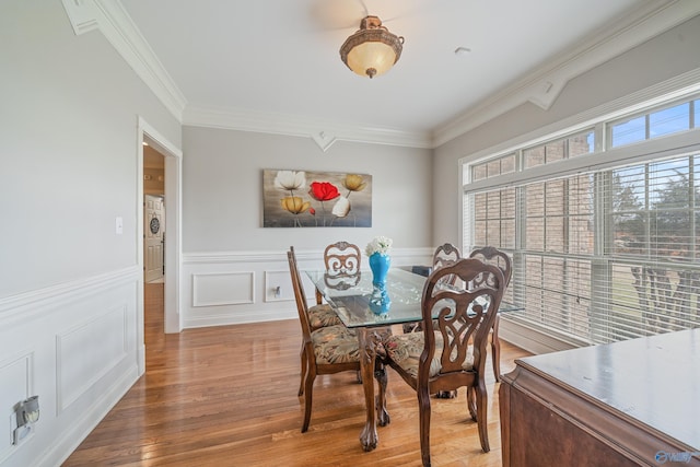 26409 Pepper Rd, Athens, AL 35613 - dining space featuring a decorative wall, wainscoting, crown molding, and wood finished floors
