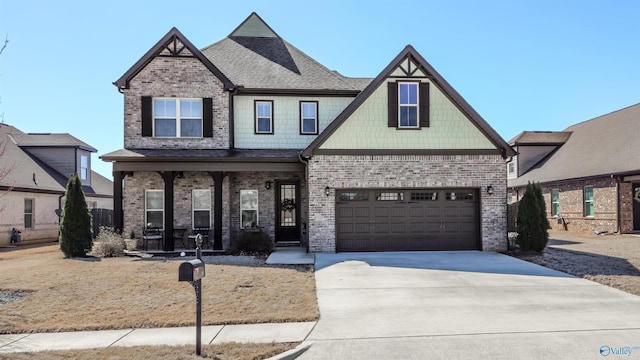 craftsman inspired home with a garage, brick siding, covered porch, and driveway