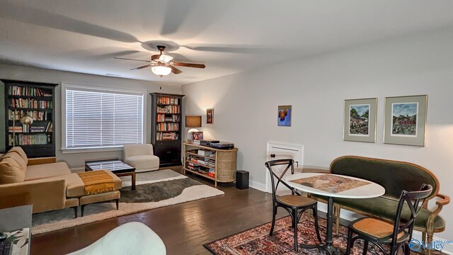 interior space with baseboards, wood finished floors, and ceiling fan