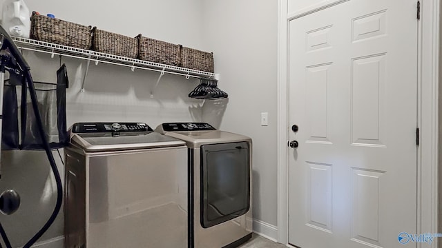 clothes washing area featuring washer and dryer, baseboards, and laundry area