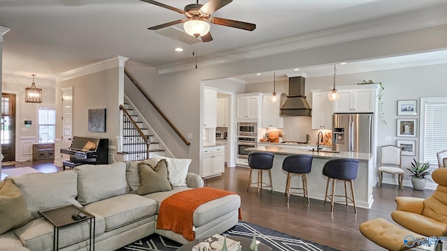 living room with dark wood-style floors, recessed lighting, ceiling fan, stairs, and crown molding