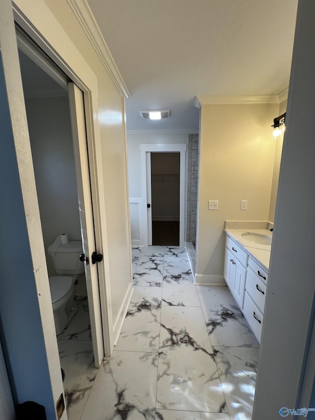 bathroom featuring vanity, toilet, and crown molding