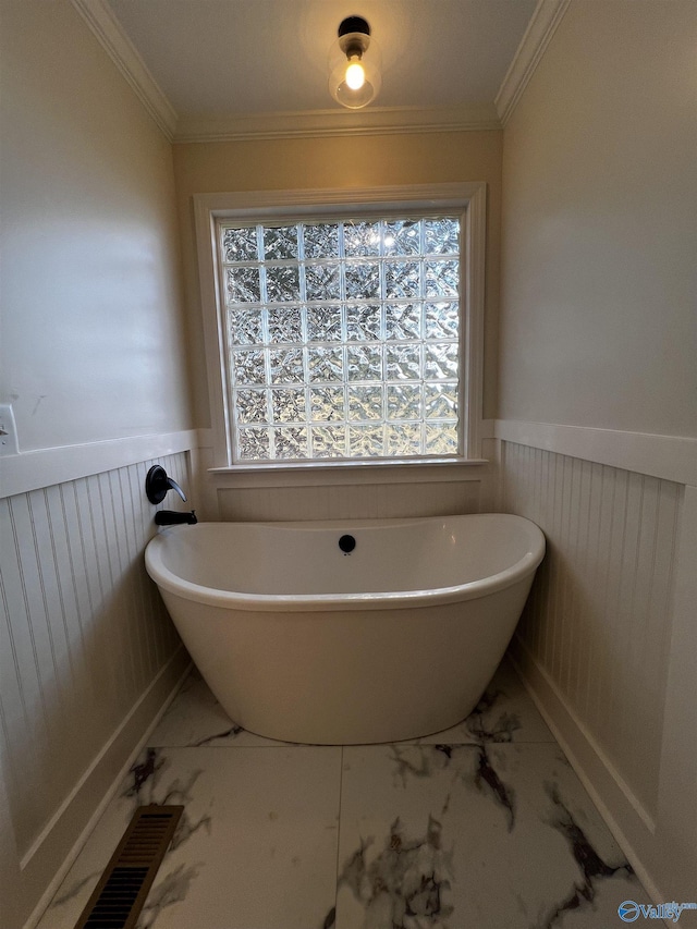 bathroom with crown molding and a tub