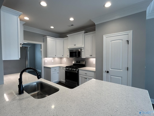 4359 Willow Bend Ln SE, Owens Cross Roads, AL 35763 - kitchen with gas stove, stainless steel microwave, crown molding, backsplash, and white cabinetry