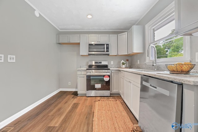 2017 Shady Lane Dr, Huntsville, AL 35810 - kitchen with sink, crown molding, light stone counters, light hardwood / wood-style flooring, and appliances with stainless steel finishes