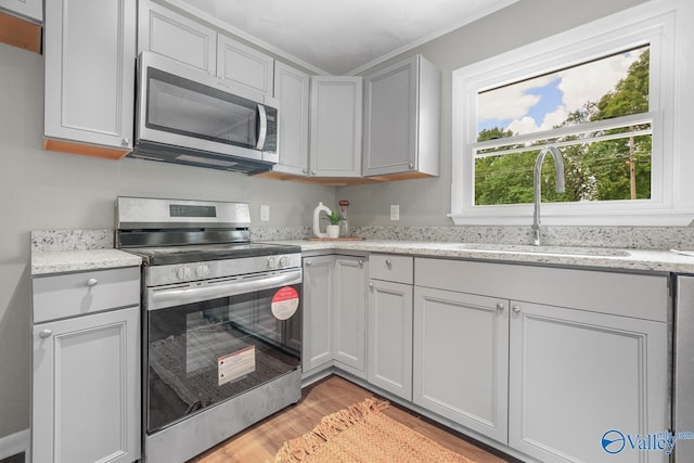 2017 Shady Lane Dr, Huntsville, AL 35810 - kitchen featuring light stone counters, appliances with stainless steel finishes, sink, and light wood-type flooring