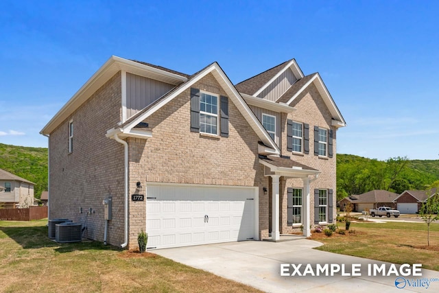 craftsman-style house featuring a garage, central air condition unit, and a front yard