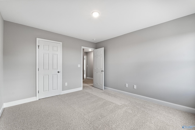 unfurnished bedroom featuring light colored carpet and a closet