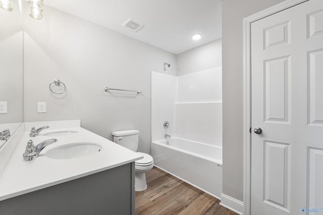 full bathroom featuring wood-type flooring, vanity, toilet, and tub / shower combination